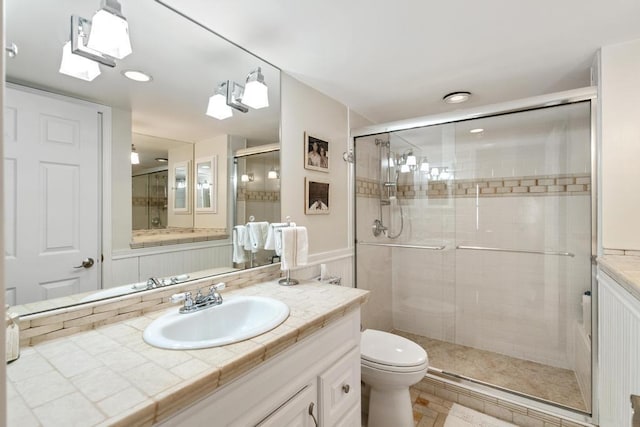 bathroom featuring an enclosed shower, vanity, and toilet