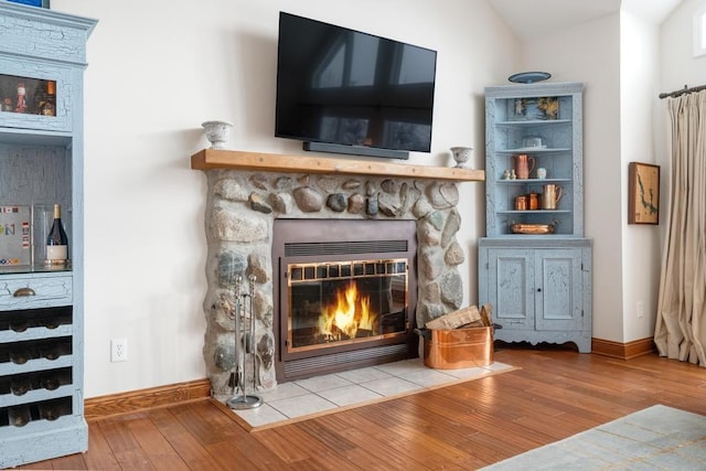 room details with a stone fireplace and hardwood / wood-style floors