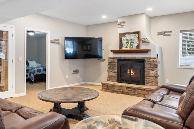 carpeted living room featuring a stone fireplace