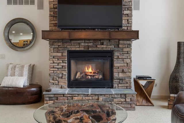 details featuring a stone fireplace and carpet flooring