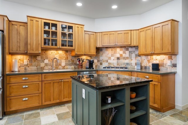 kitchen with a kitchen island, dark stone countertops, decorative backsplash, and sink