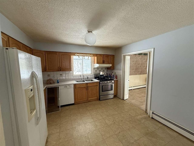 kitchen with a baseboard heating unit, sink, white appliances, and decorative backsplash