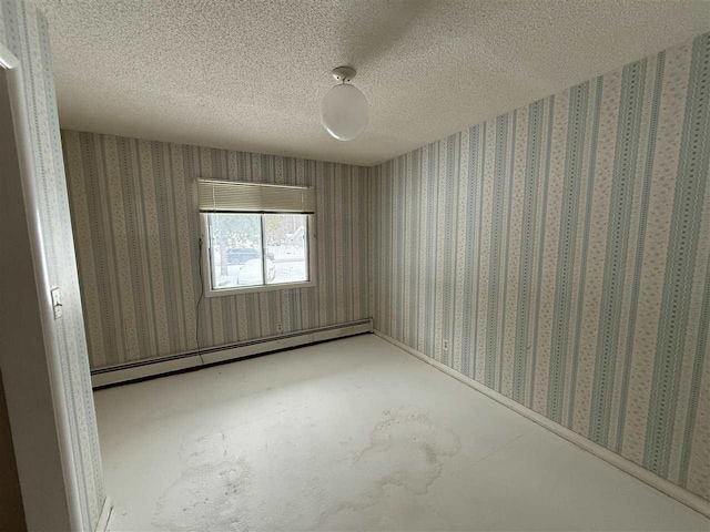 empty room with a baseboard heating unit, concrete floors, and a textured ceiling