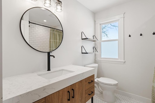 bathroom with a wealth of natural light, toilet, vanity, and tile patterned flooring