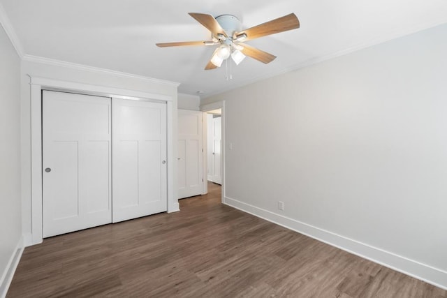 unfurnished bedroom with ceiling fan, dark wood-type flooring, a closet, and ornamental molding