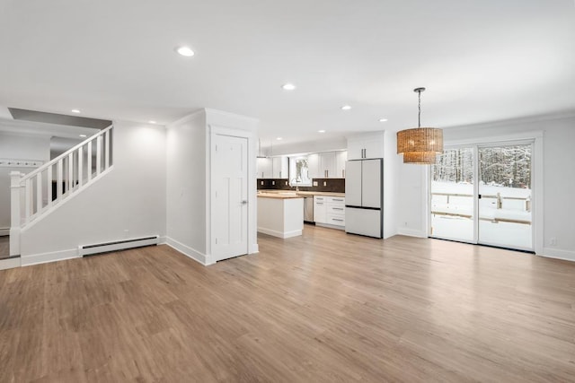 unfurnished living room featuring light wood-type flooring, crown molding, and a baseboard radiator