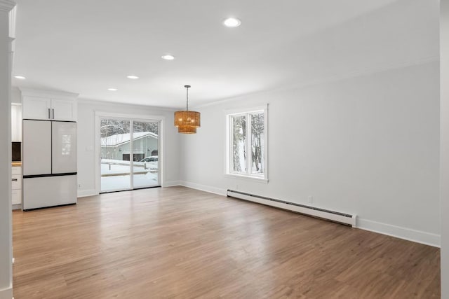 unfurnished room featuring a wealth of natural light, crown molding, light hardwood / wood-style floors, and a baseboard radiator