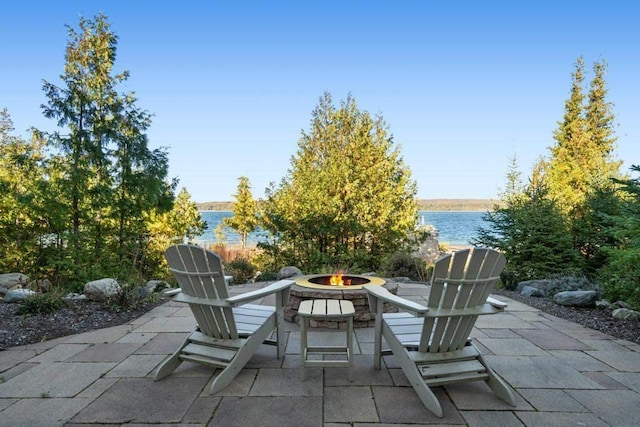 view of patio / terrace with a water view and a fire pit