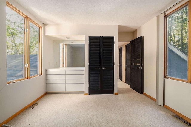 unfurnished bedroom featuring a textured ceiling and multiple windows