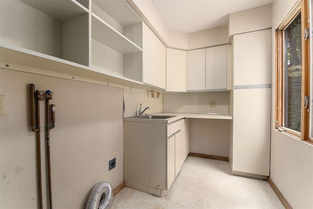 clothes washing area with a wealth of natural light, sink, light carpet, hookup for an electric dryer, and cabinets