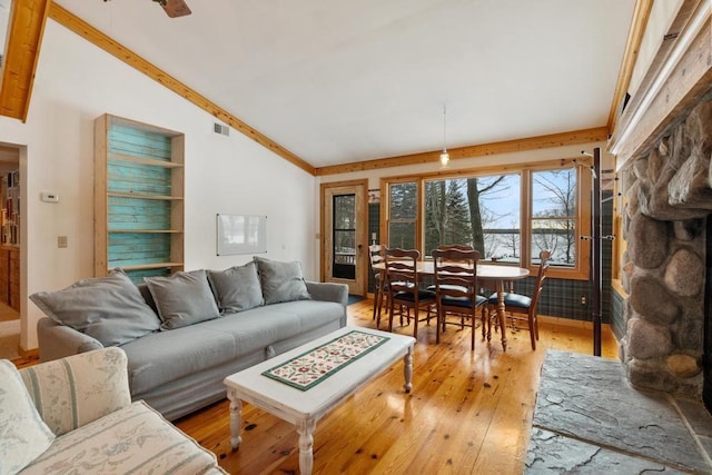 living room with ceiling fan, ornamental molding, lofted ceiling, and light hardwood / wood-style floors