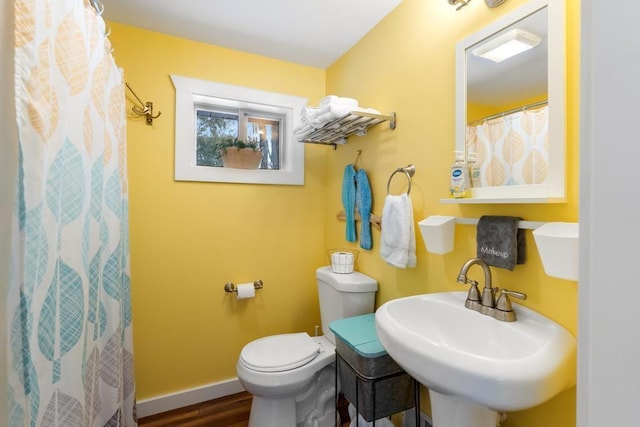 bathroom with toilet, a shower with curtain, wood-type flooring, and sink