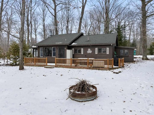 snow covered property with a deck and a fire pit