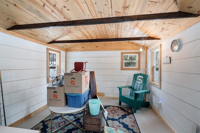 living area with concrete floors, wooden ceiling, beam ceiling, and wooden walls