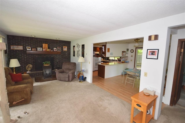 carpeted living room with a textured ceiling and a wood stove