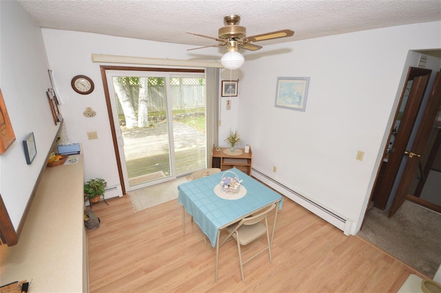 dining room featuring ceiling fan, baseboard heating, a textured ceiling, and light hardwood / wood-style flooring