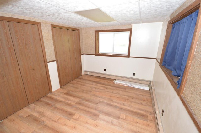 unfurnished bedroom featuring light wood-type flooring and multiple closets