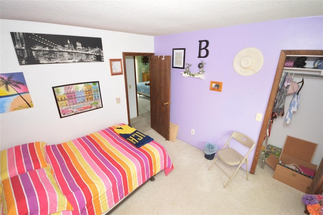 carpeted bedroom with a textured ceiling and a closet