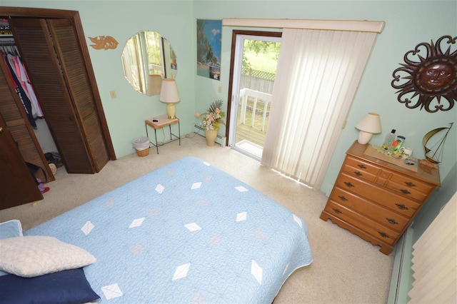 carpeted bedroom with access to outside, a closet, and a baseboard heating unit