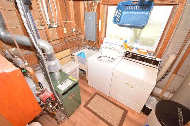 laundry area with washer and dryer, light hardwood / wood-style floors, electric panel, and sink