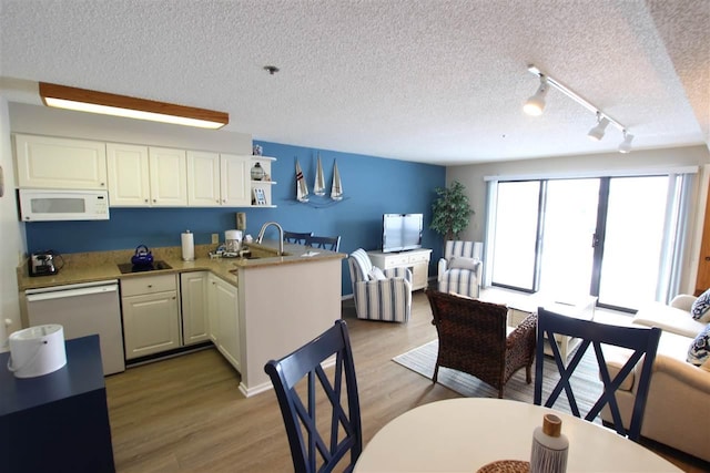 kitchen featuring dishwashing machine, white cabinets, a textured ceiling, light hardwood / wood-style floors, and kitchen peninsula