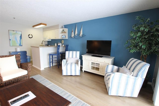 living room with light hardwood / wood-style floors and a textured ceiling