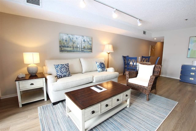 living room with a textured ceiling and light hardwood / wood-style floors