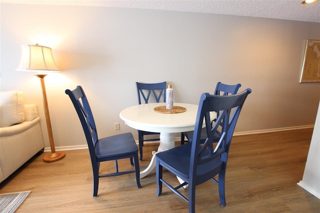 dining area with a textured ceiling and hardwood / wood-style flooring