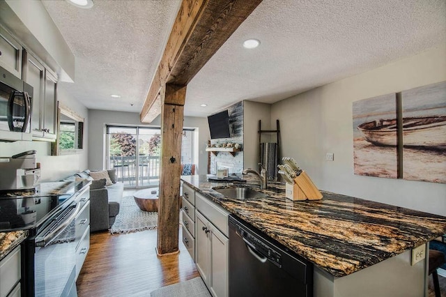 kitchen featuring dishwasher, electric range, sink, a textured ceiling, and dark stone counters