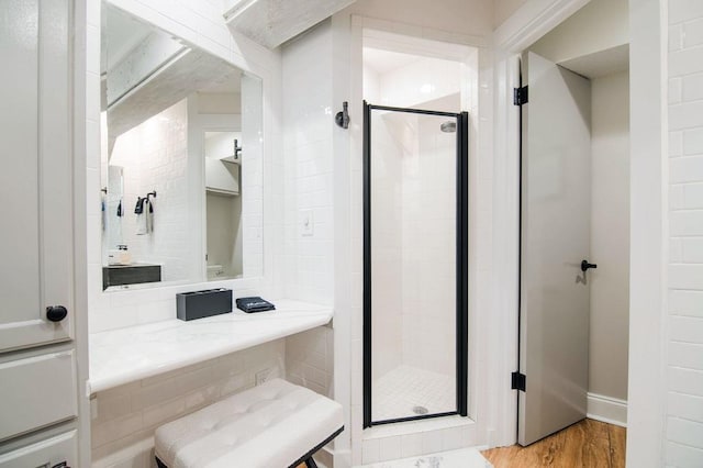 bathroom with hardwood / wood-style flooring and walk in shower