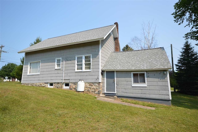 rear view of house featuring a yard