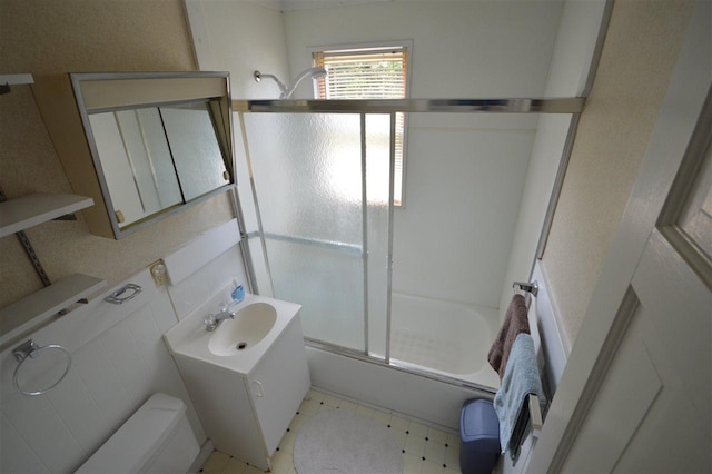 full bathroom featuring toilet, vanity, and shower / bath combination with glass door