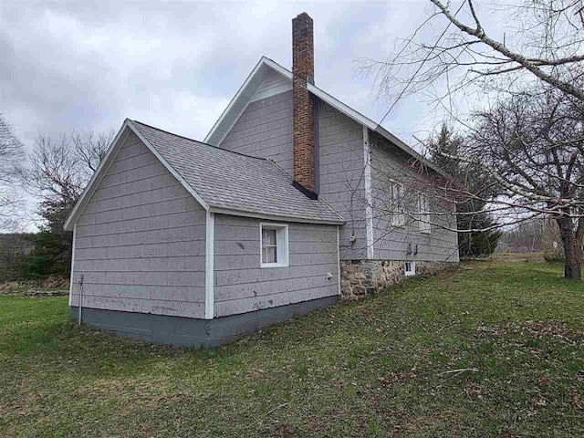 2010 S Wilson Rd, East Jordan, MI 49727 - view of side of property with a yard, a chimney, and roof with shingles