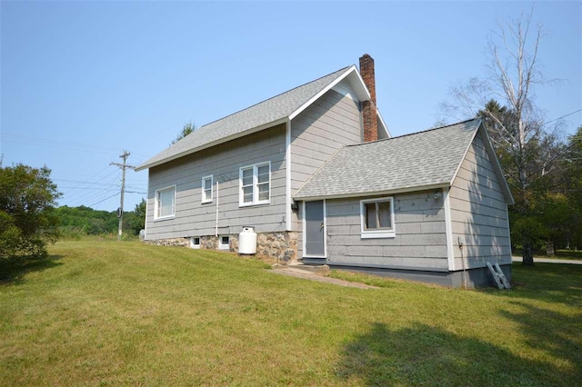 rear view of house featuring a lawn