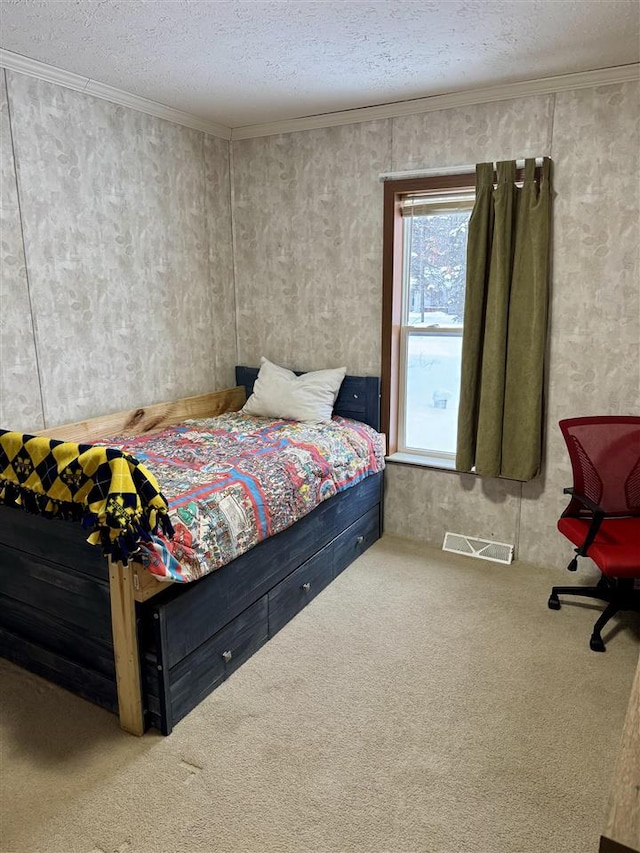 carpeted bedroom with ornamental molding and a textured ceiling