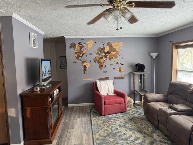 living room with ceiling fan, crown molding, wood-type flooring, and a textured ceiling