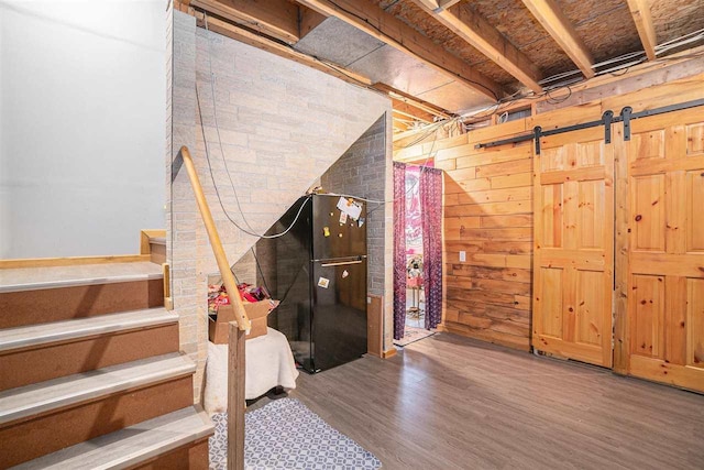 basement featuring hardwood / wood-style flooring and wooden walls