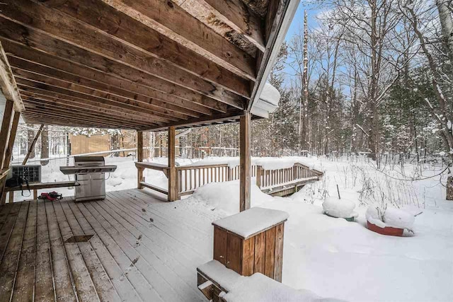 snow covered deck with a grill