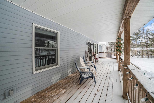 snow covered deck with a porch