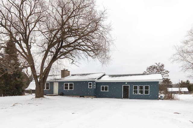 view of snow covered back of property