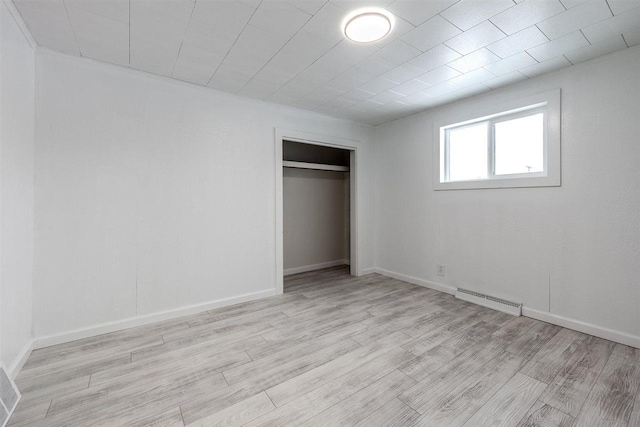 unfurnished bedroom featuring light hardwood / wood-style floors and a closet