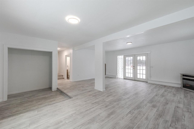 basement with light wood-type flooring and french doors