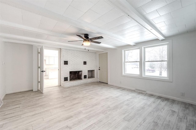 unfurnished living room featuring ceiling fan, light hardwood / wood-style floors, beamed ceiling, and a brick fireplace