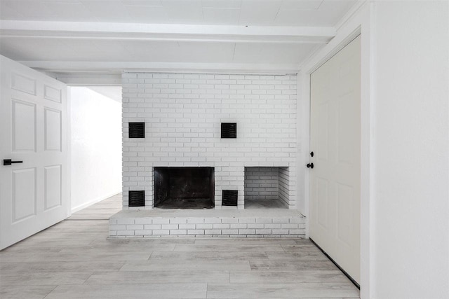 details featuring a brick fireplace, beam ceiling, and wood-type flooring