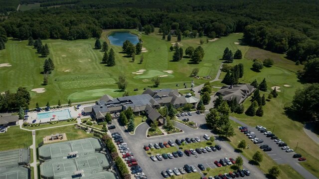 bird's eye view with golf course view and a view of trees