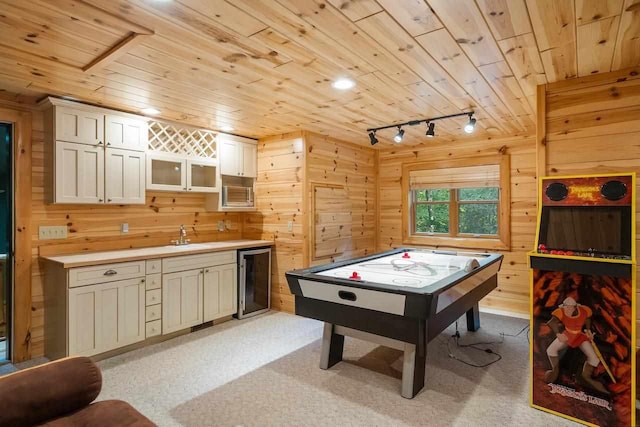 rec room with wine cooler, wood ceiling, wooden walls, and rail lighting