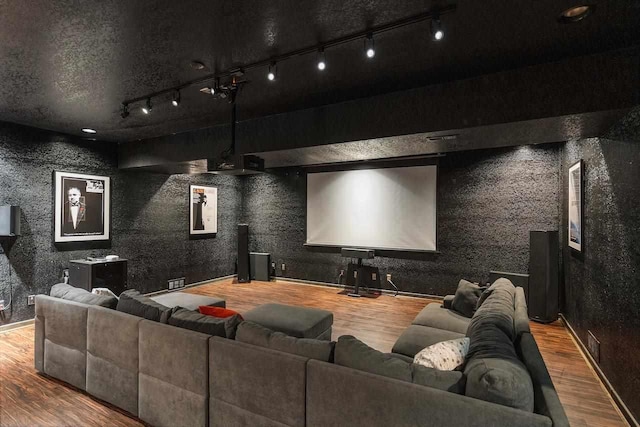 cinema room featuring wood-type flooring and rail lighting