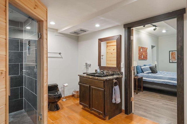 bathroom featuring vanity, a shower with door, and toilet