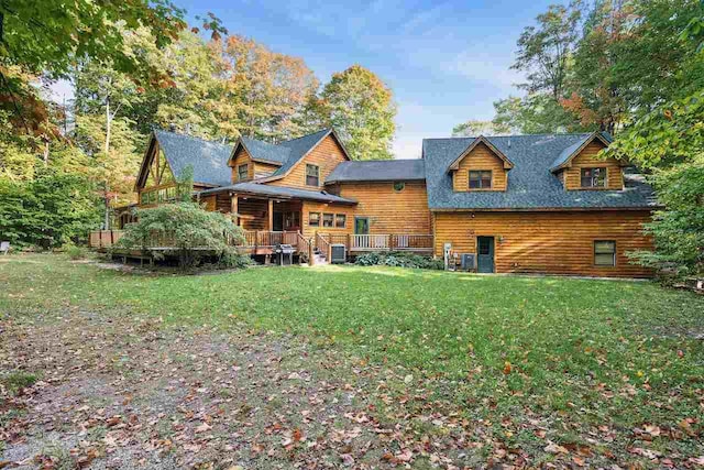 rear view of property featuring cooling unit and a lawn