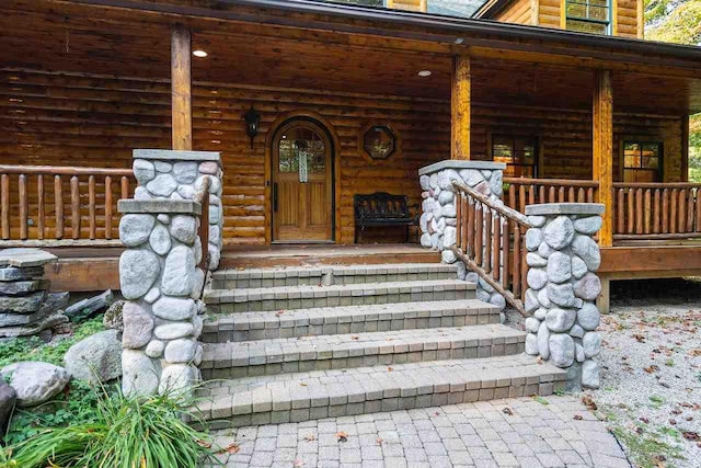 view of exterior entry featuring covered porch